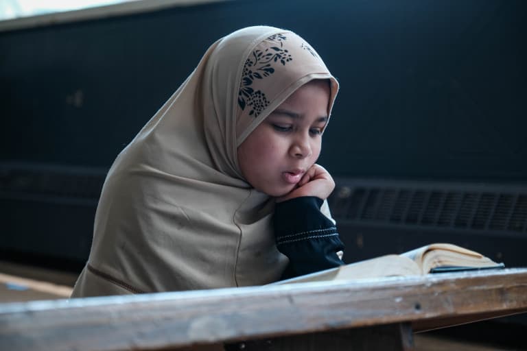 Girl studying an open Quran